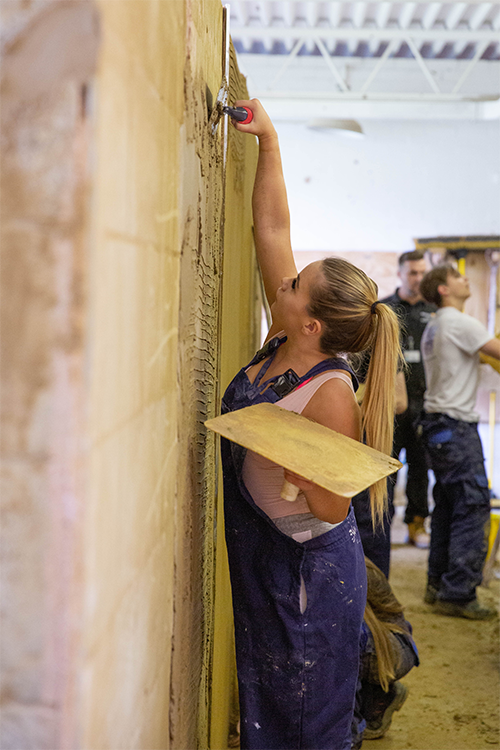 Student plastering a wall