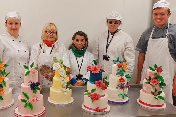 Students standing with their cakes