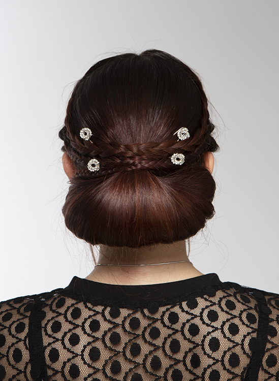 Back of student's head showing hair styled into a low bun with four clips
