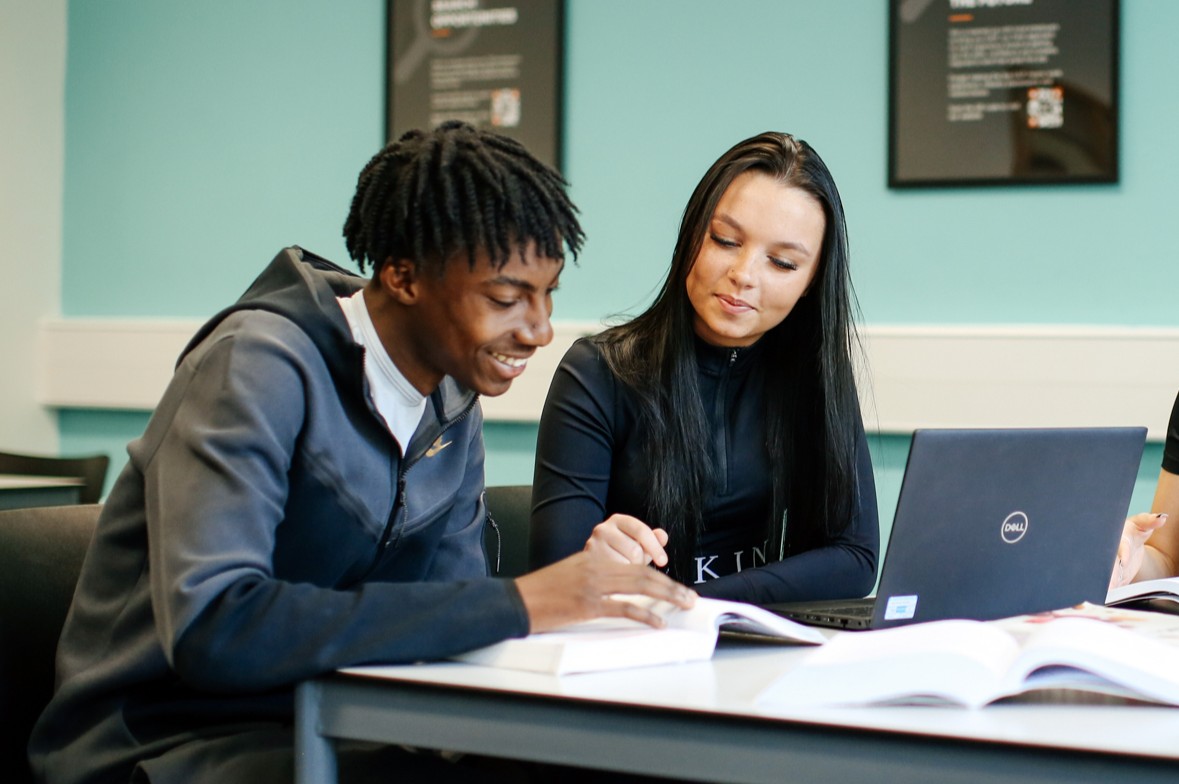 Student standing holding a book