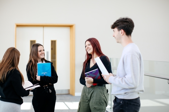 Students stood chatting with books