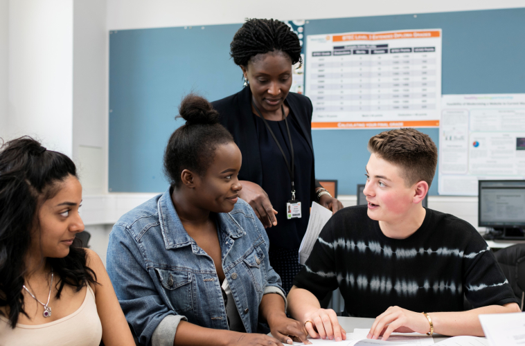 Three students and a teacher discussing a subject
