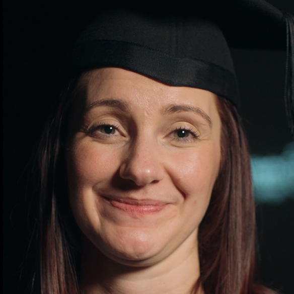 Sam smiling looking at the camera with her graduation hat on
