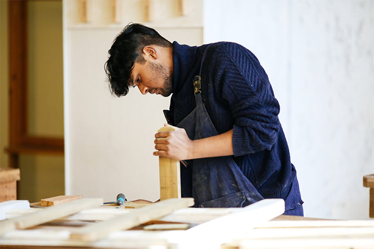 Student adding a wooden block to work