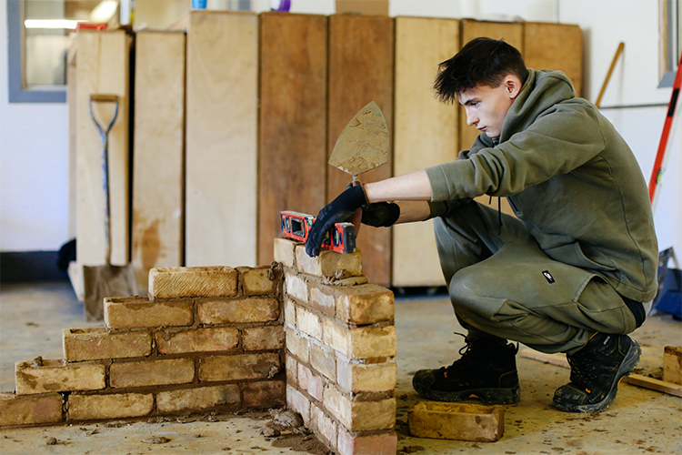 Student laying bricks