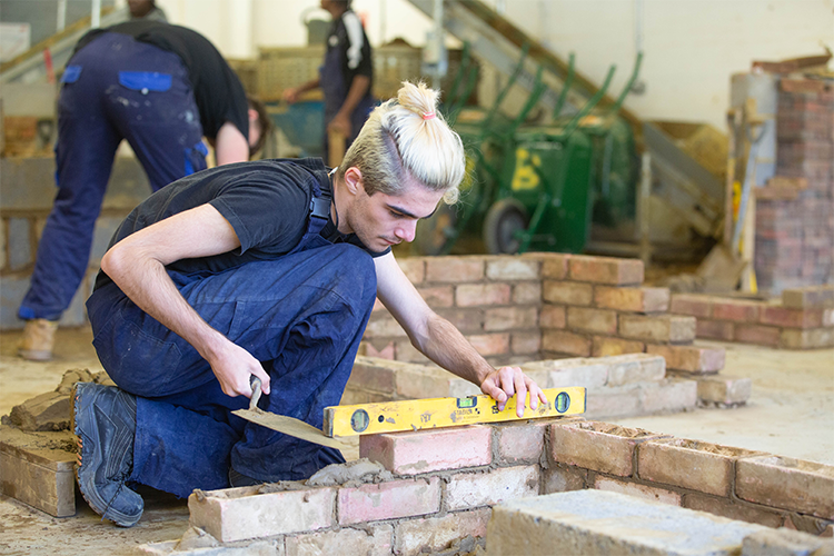 Student laying bricks