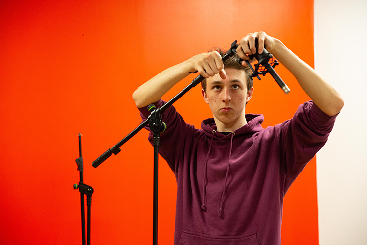 Student helping set up music equipment