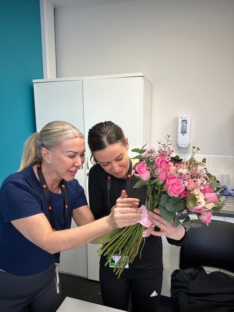 Tutor and student holding flowers