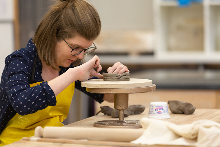 student creating a pottery project