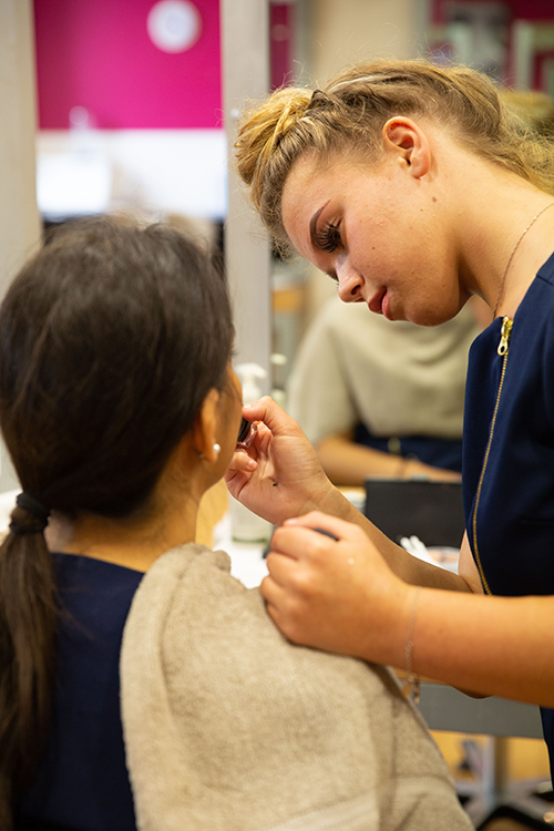 Student applying make-up to a client