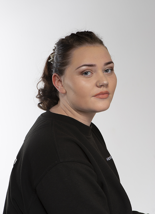 Student posing facing camera with subtle makeup