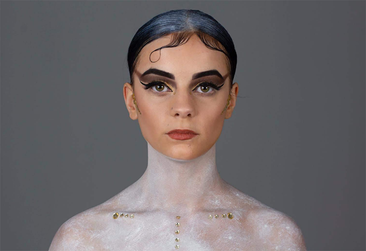 Student with dramatic makeup looking directly at camera
