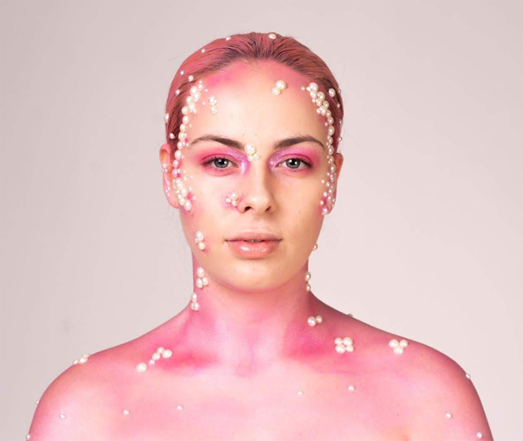 Student with pink makeup looking directly at camera