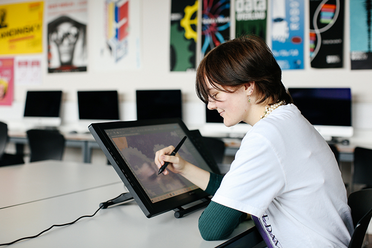 Student drawing a digital illustration on a tablet