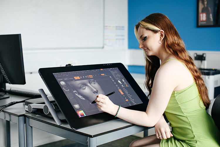 Student drawing a digital illustration on a tablet