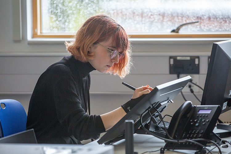 Student drawing a digital illustration on a tablet