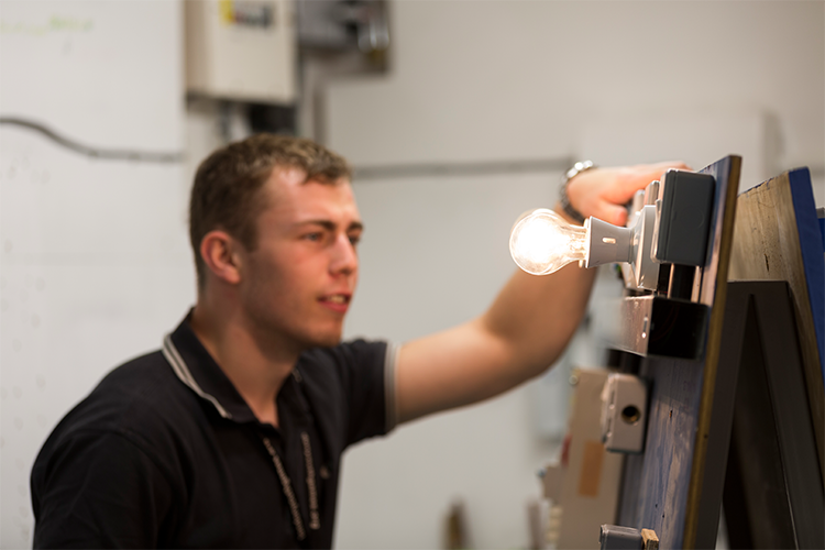 Student fixing a lightbulb