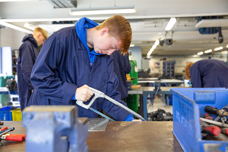 Student cutting metal