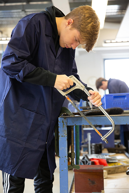 Student sawing through metal