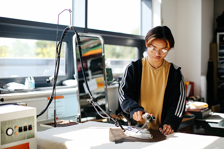Student ironing fabric