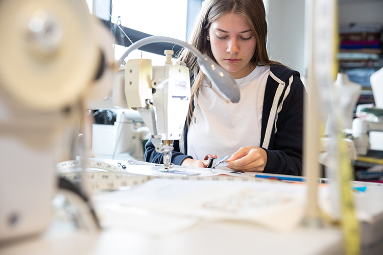 Student cutting cotton thread