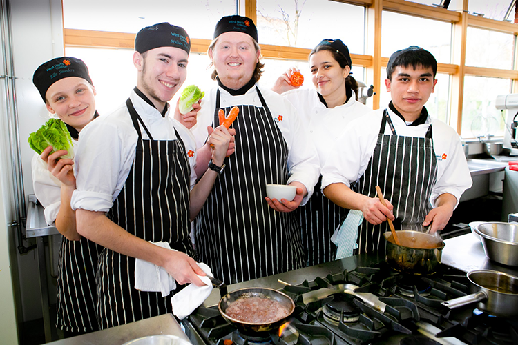 students gathered around a hob