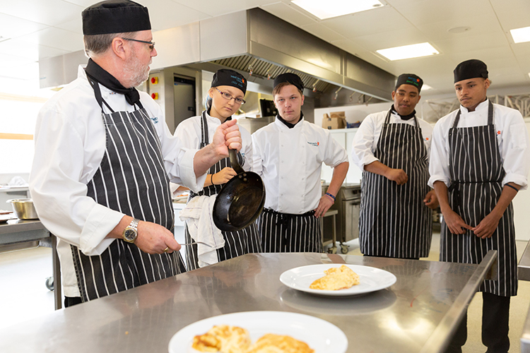 Group of students stood around plates of food