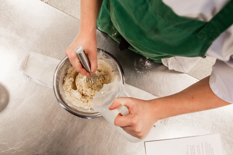 Student mixing food in a bowl
