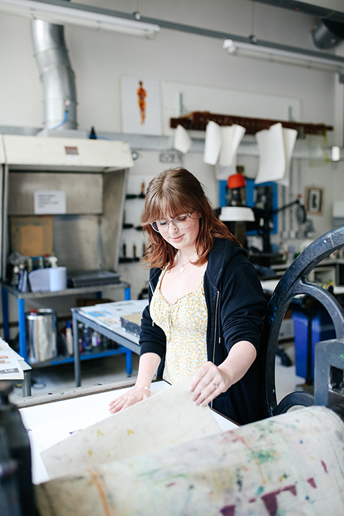 Student looking at screen printing artwork