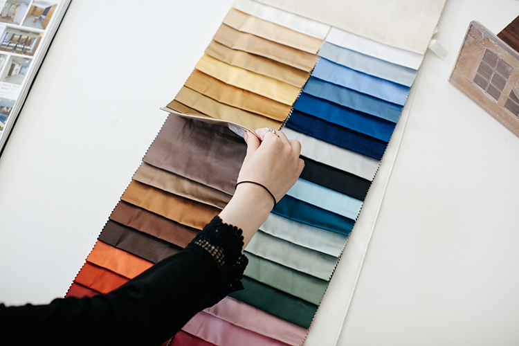 Student flicking through fabric samples