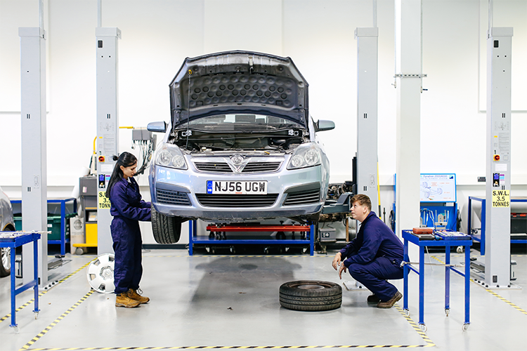 Two students inspecting a car