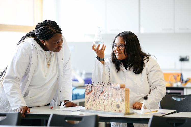 Two students looking at flask