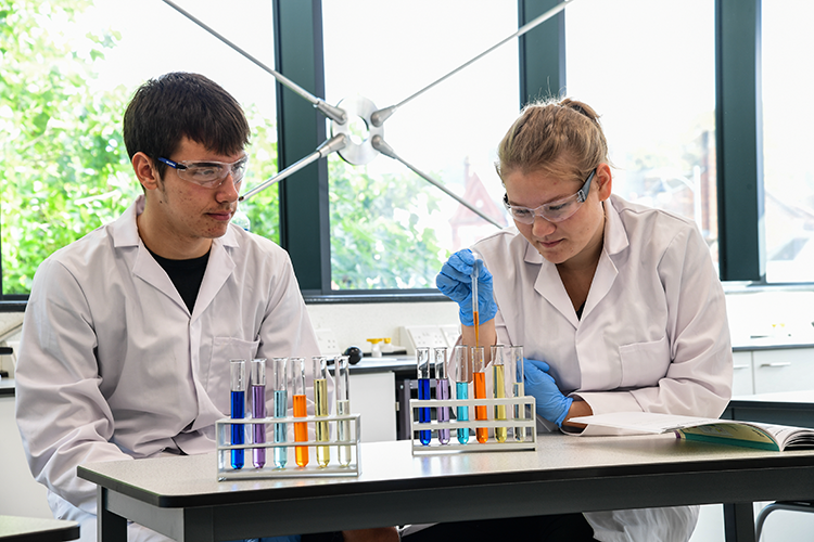 Students looking at colourful test-tubes 