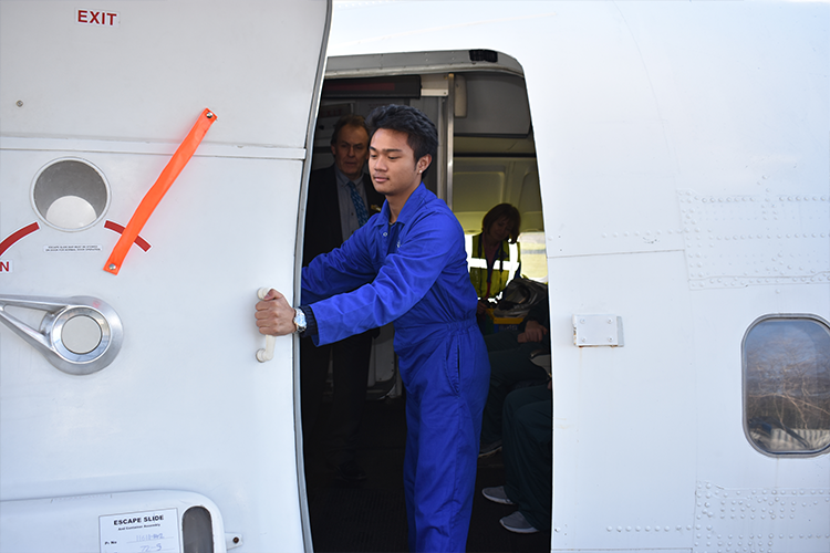 Student closing a plane door