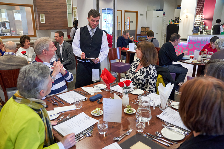 Hospitality student taking diners orders