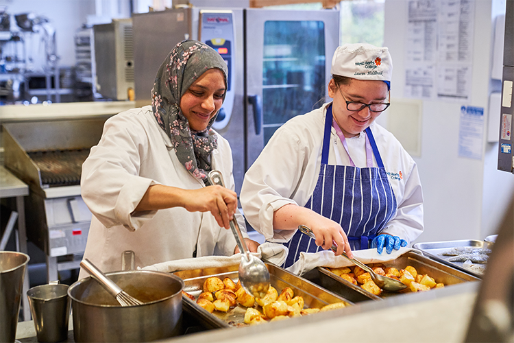 Professional cookery students roasting potatoes