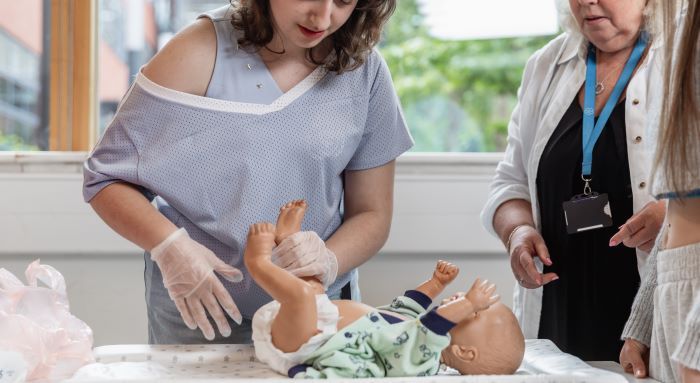 students changing a doll's nappy