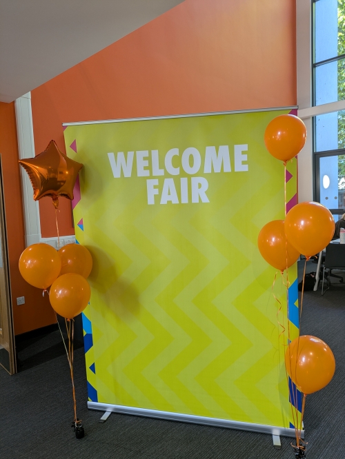 Welcome Fair banner with balloons on either side