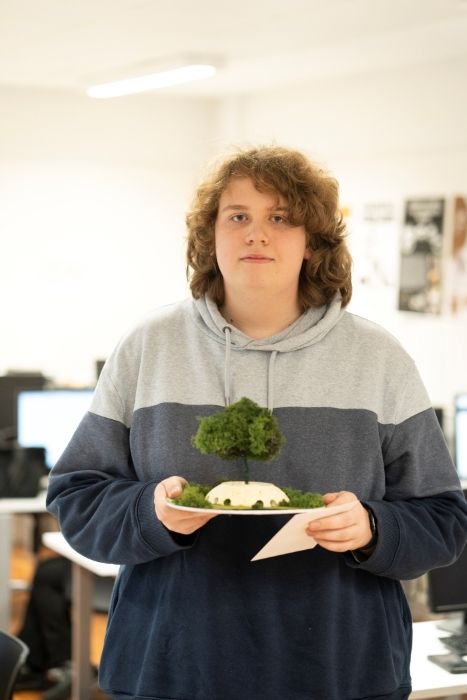 Zack looking at camera holding his winning model